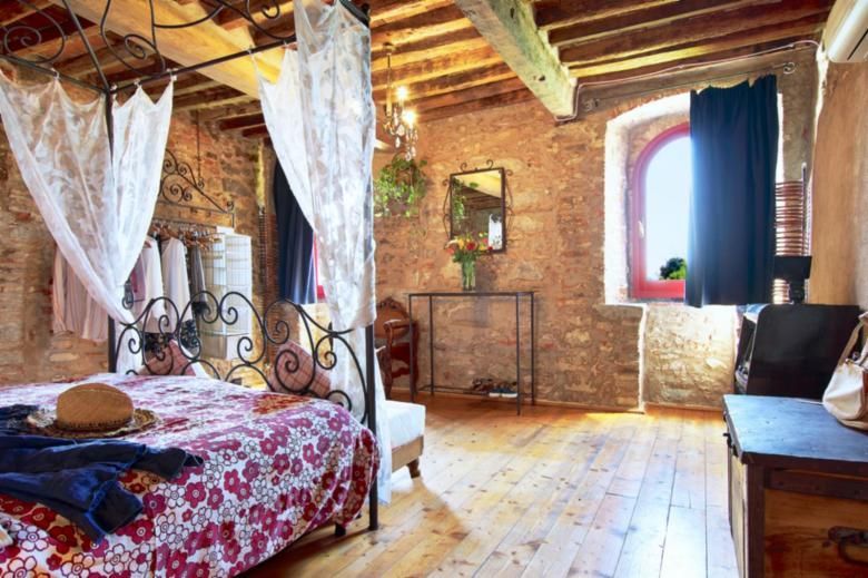 Letto in ferro battuto in camera rustica in Toscana