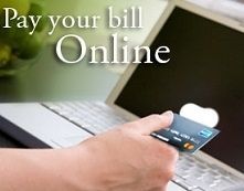 Hand holding credit card over laptop with “Pay your bill Online” text