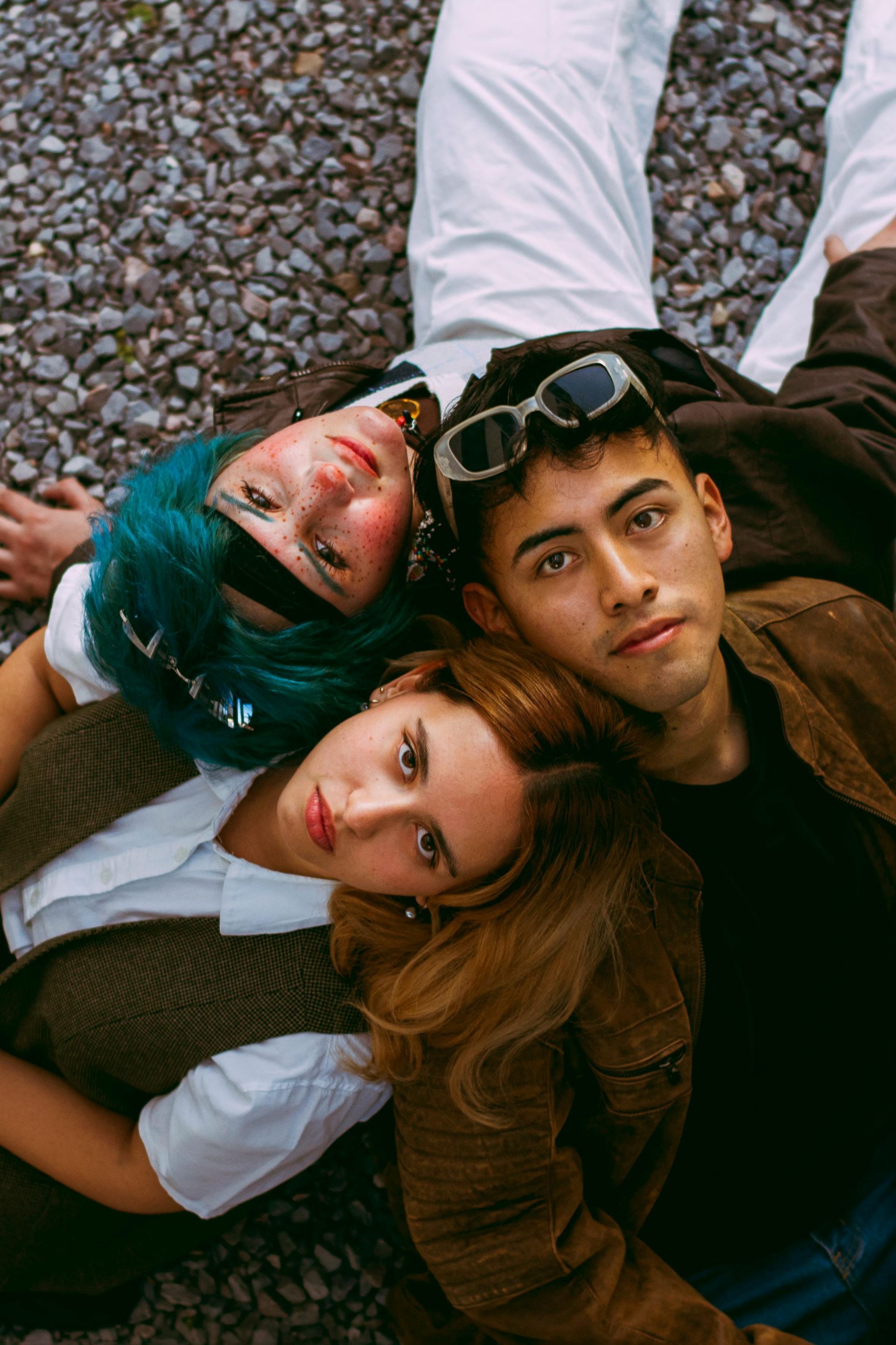 A group of young people are laying on the ground together.