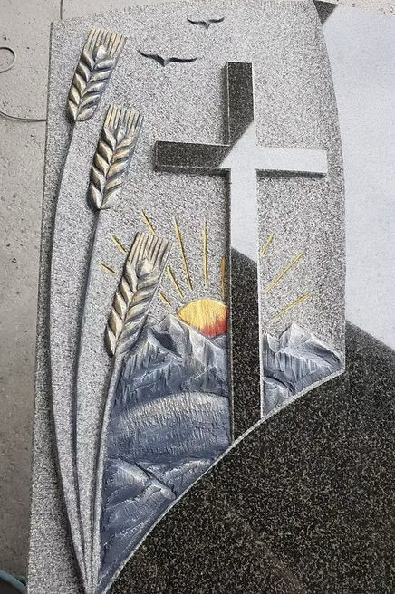 Stilisierte Gedenktafel für eine Kirche mit Kreuz, Weizenähren und Sonnenaufgang über den Bergen