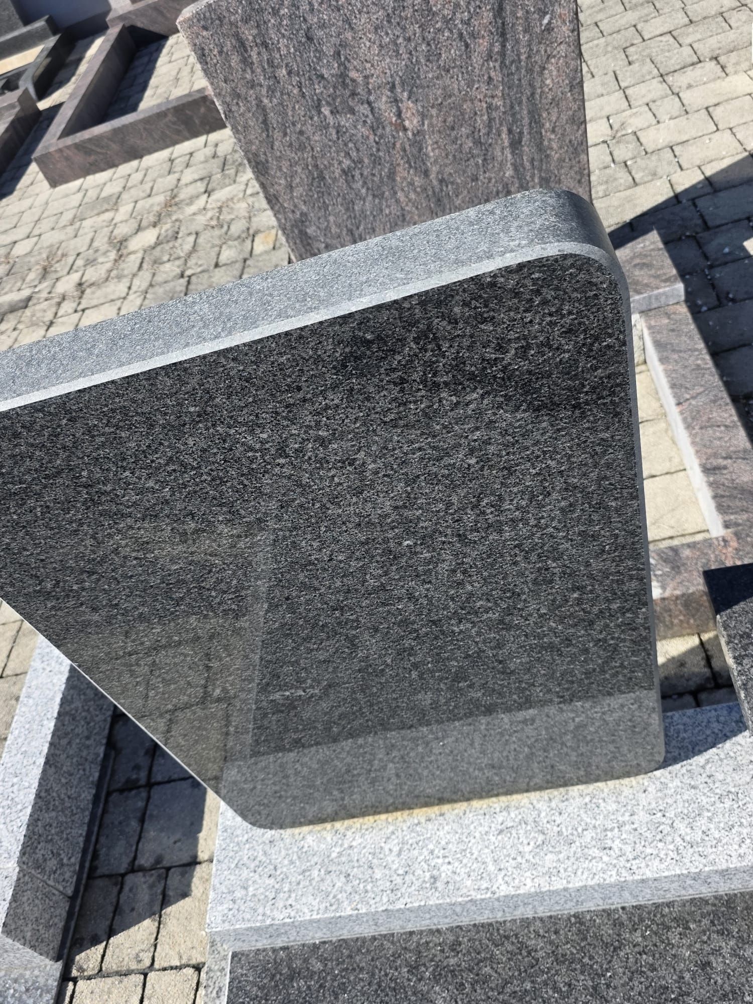 Granit-Gedenksteine auf einem gepflasterten Außenplatz, Nahaufnahme.