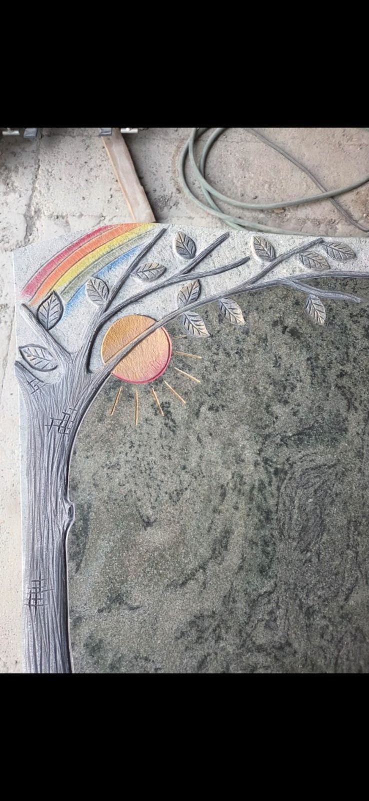 Grabstein mit Regenbogen, Sterne und ein planetenähnlicher Kreis