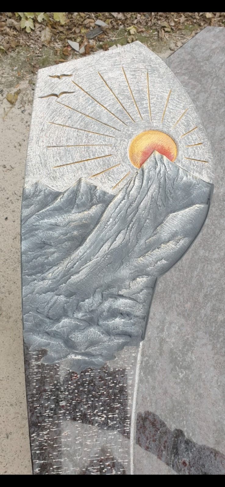 Sonnenaufgang über grauen Berggipfeln in einem Steinmosaik