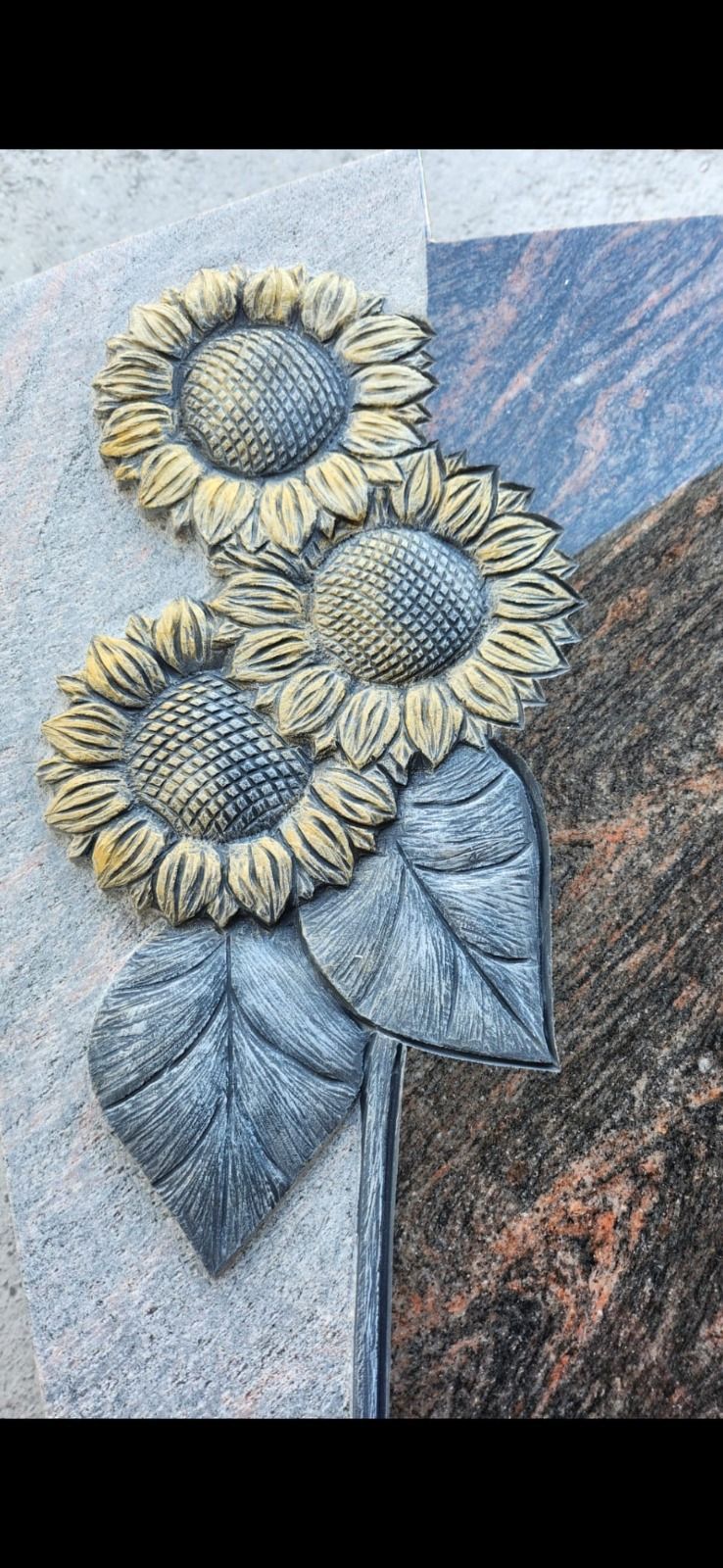 Dekorative Sonnenblumen mit blauen Blättern in einem strukturierten Reliefbild vor einem grau-blauen Hintergrund