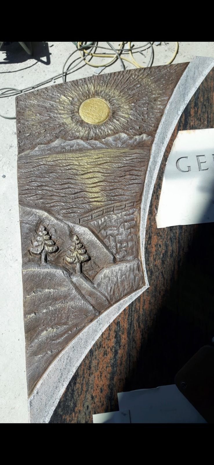 Ein mondbeschienenes Steinrelief mit einer Berglandschaft und zwei Wanderern, die einen Pfad hinaufsteigen