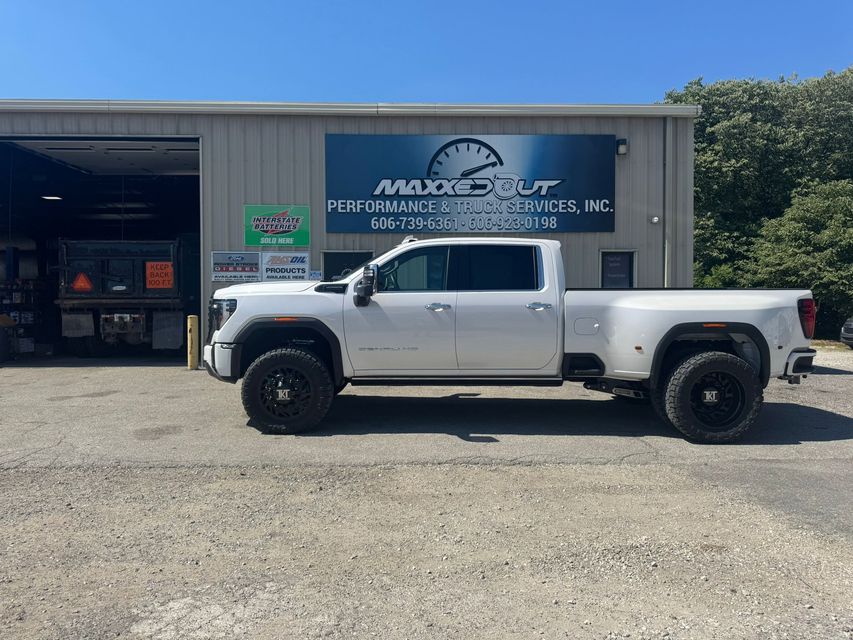 White truck parked in front of a building with a sign for MaxSpot, Inc.