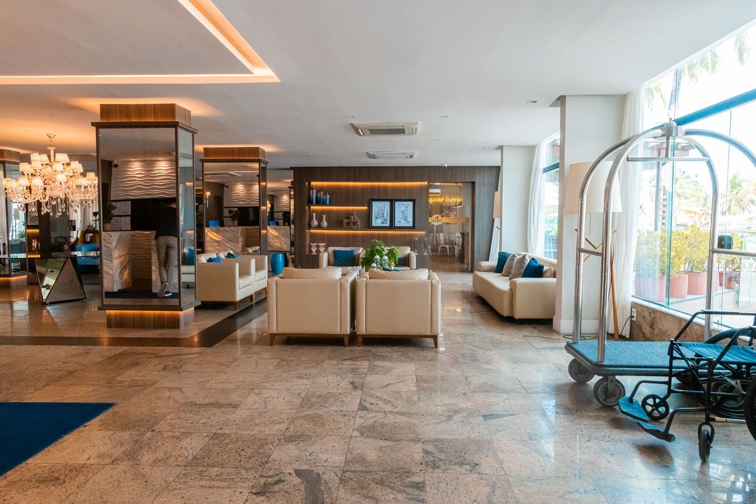 Um lobby de hotel com um carrinho de bagagem no meio.