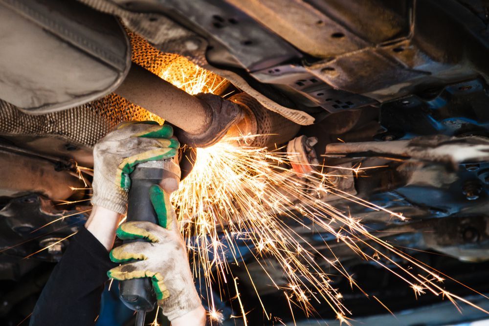 Mechanic Grinding Under a Vehicle, Sending Bright Sparks Across the Underside — Wingham Mechanical in Wingham, NSW