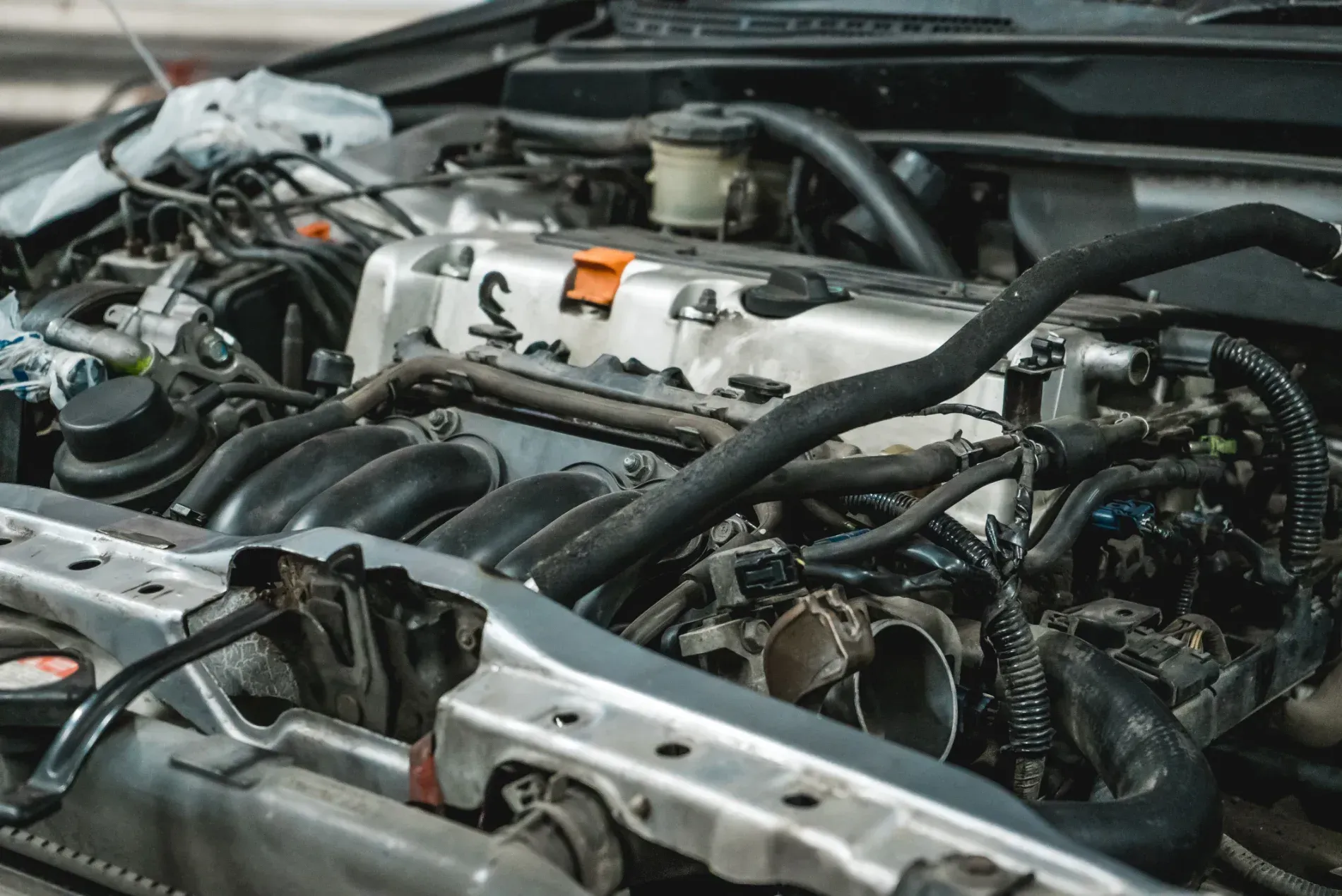 Close-Up of A Car Engine Bay with Exposed Hoses, Wiring, and Metal Components — Wingham Mechanical in Wingham, NSW