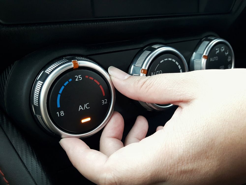 Hand Adjusting a Car Climate Control Dial, With Temperature and a/C Indicators Visible — Wingham Mechanical in Wingham, NSW