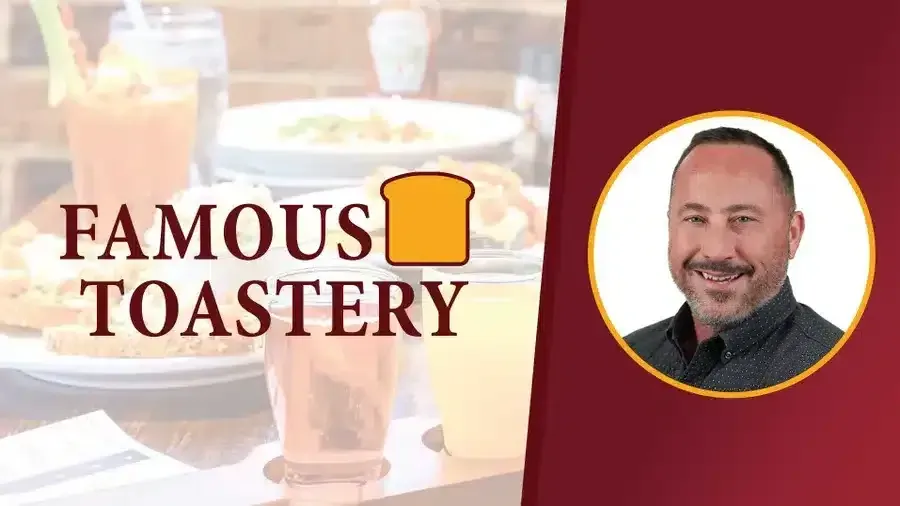 A man is standing in front of a sign that says famous toastery.