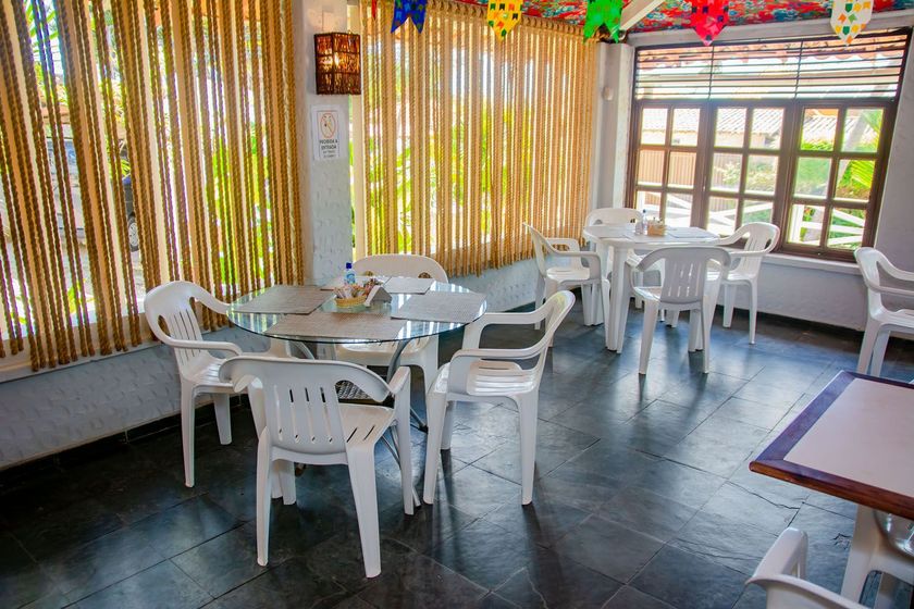 Um restaurante com mesas e cadeiras e balões pendurados no teto.