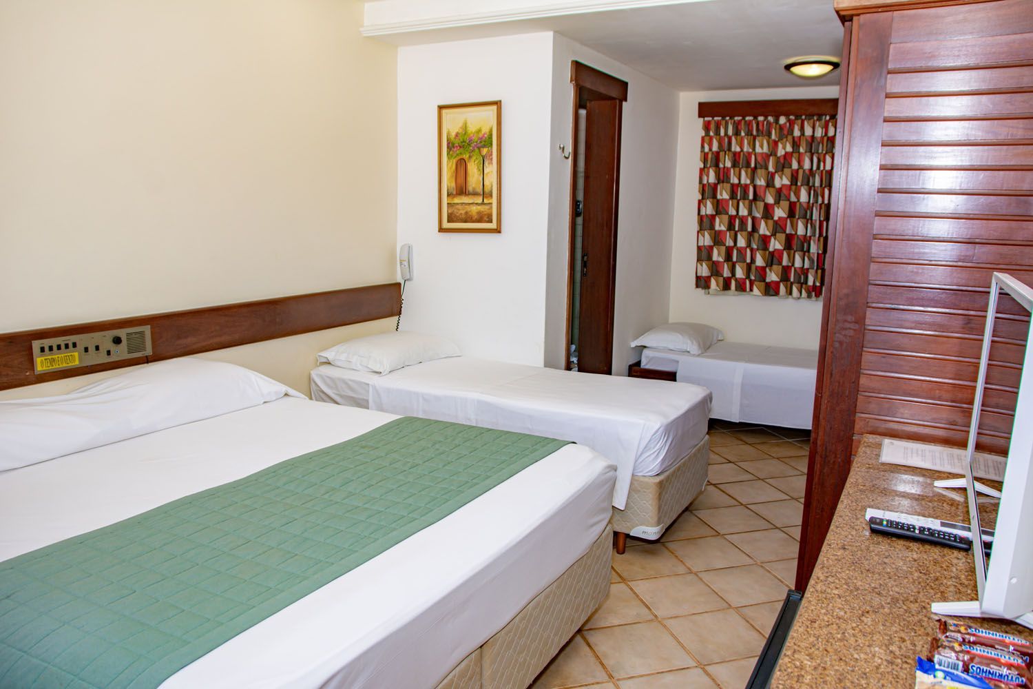 Um quarto de hotel com duas camas e uma televisão