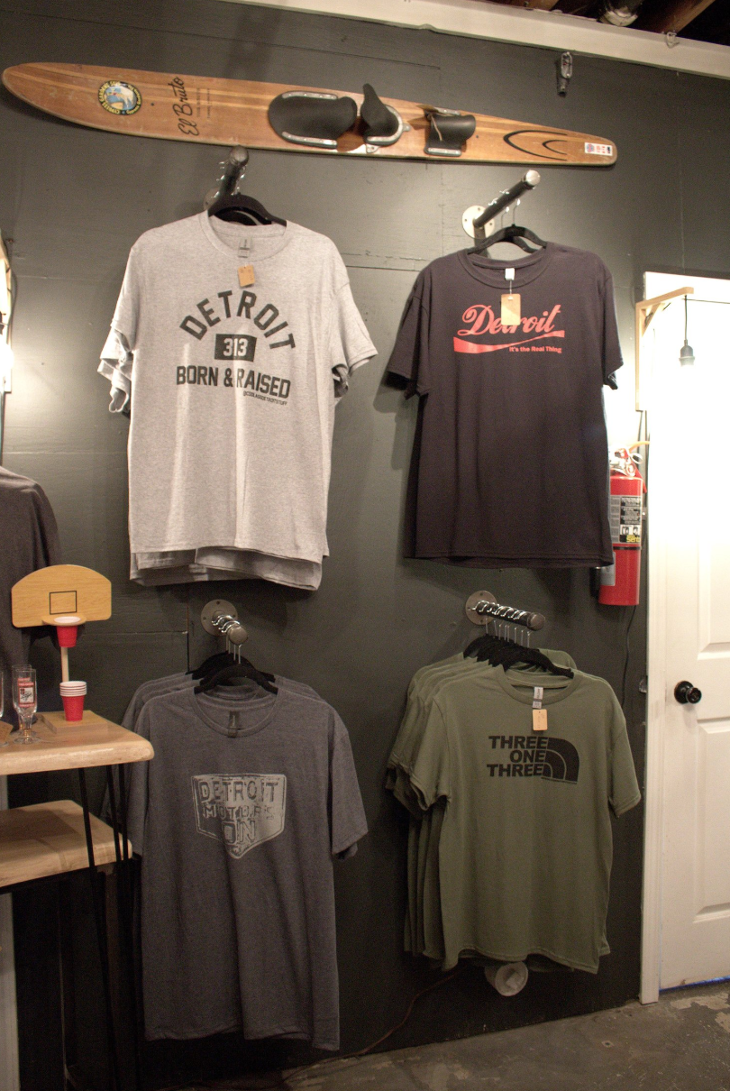 A t-shirt that says detroit is hanging on a wall