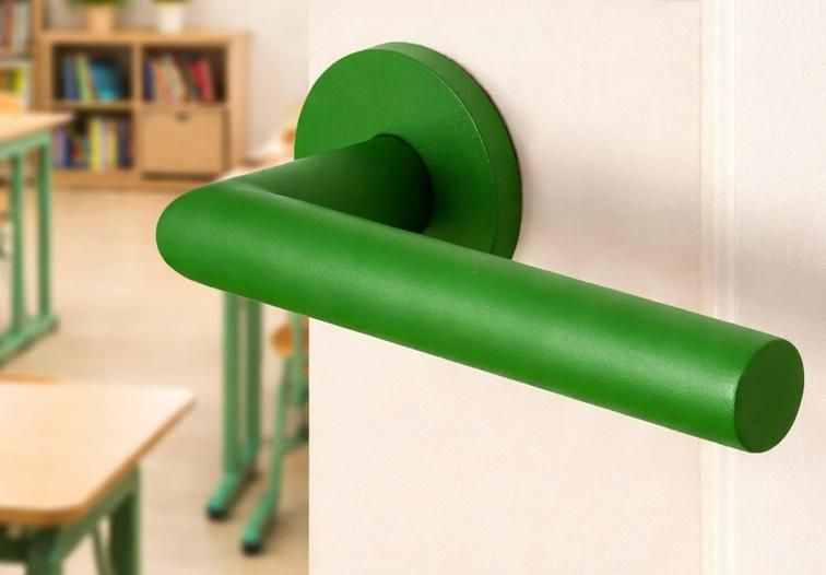 Mensen vergelijken verfstalen in een waaier en kiezen uit neutrale en warme kleurstalen op een muur.