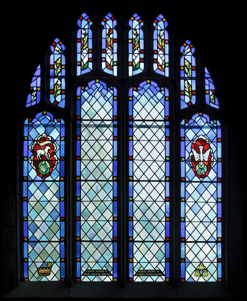 Stained glass window with blue and white diamond pattern and crests.