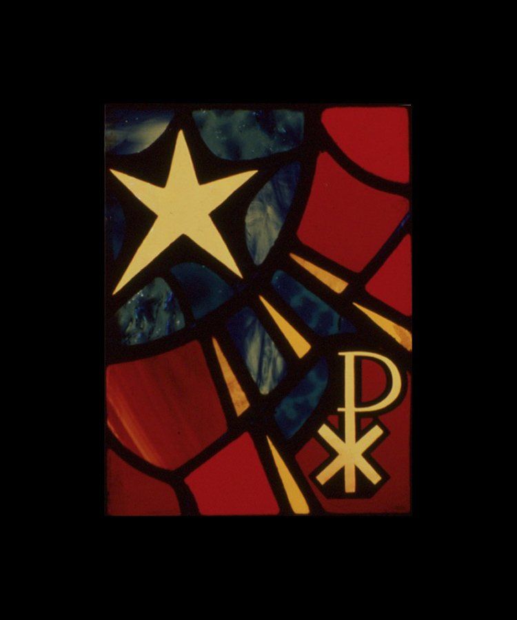Stained-glass window with gold star, Chi Rho symbol, red and blue panes.