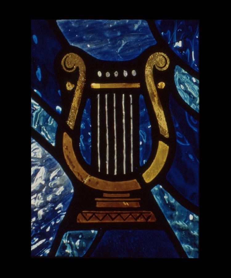 Gold and white lyre on blue and white stained glass.