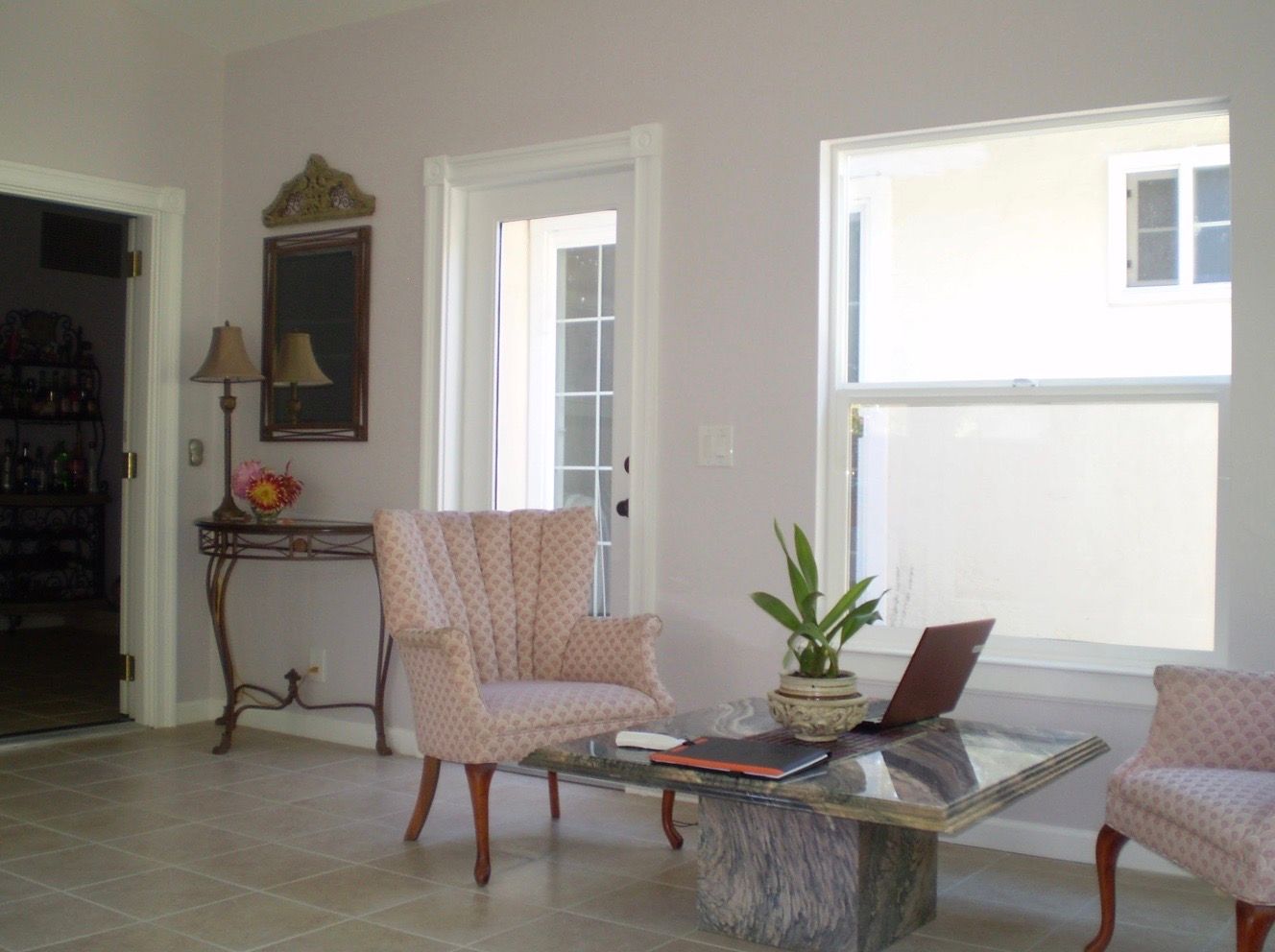 A bright, modern kitchen with warm wooden cabinets, a central island, stainless steel appliances, and hardwood floors.