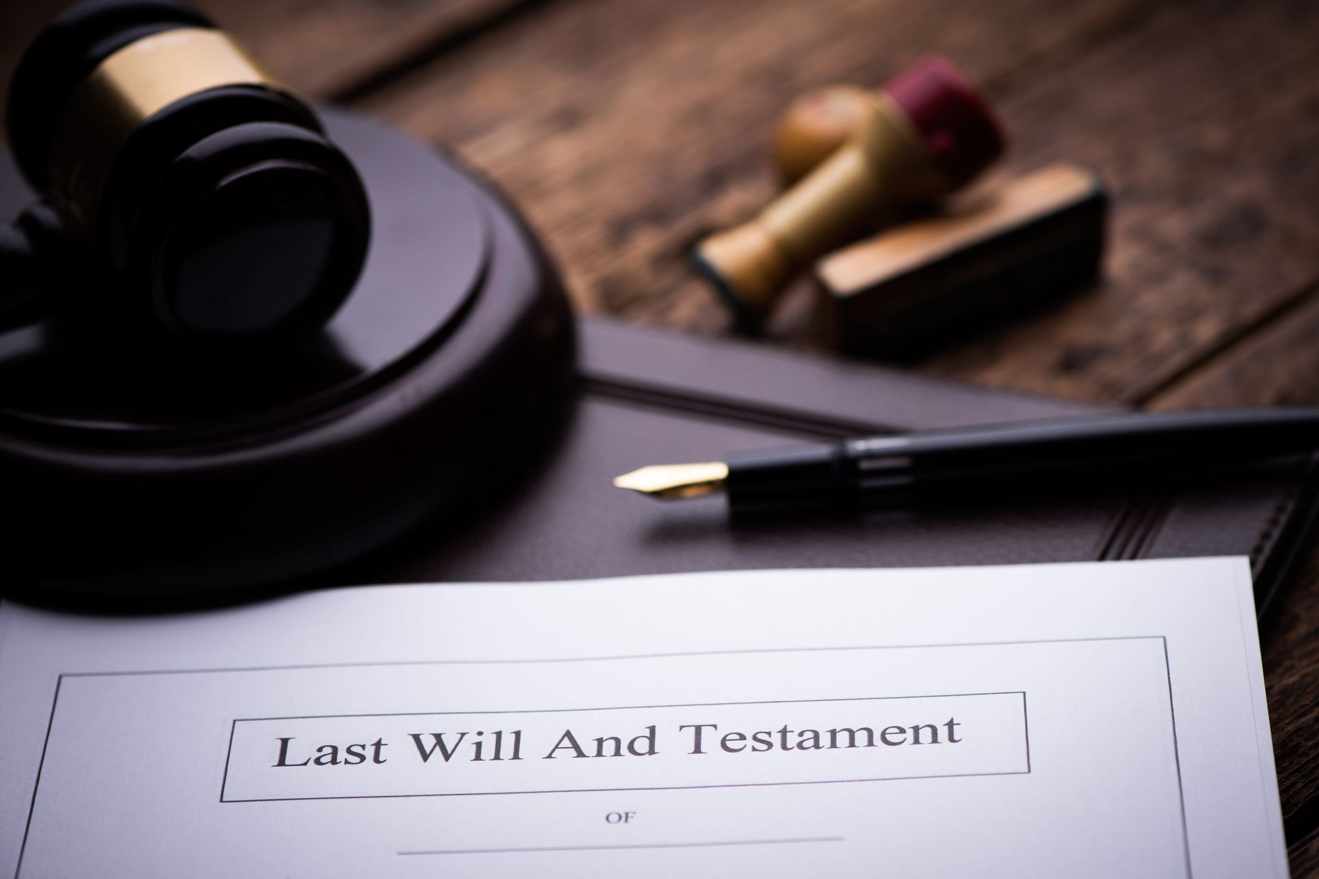Last Will and Testament document with pen, stamp, and ink on a desk