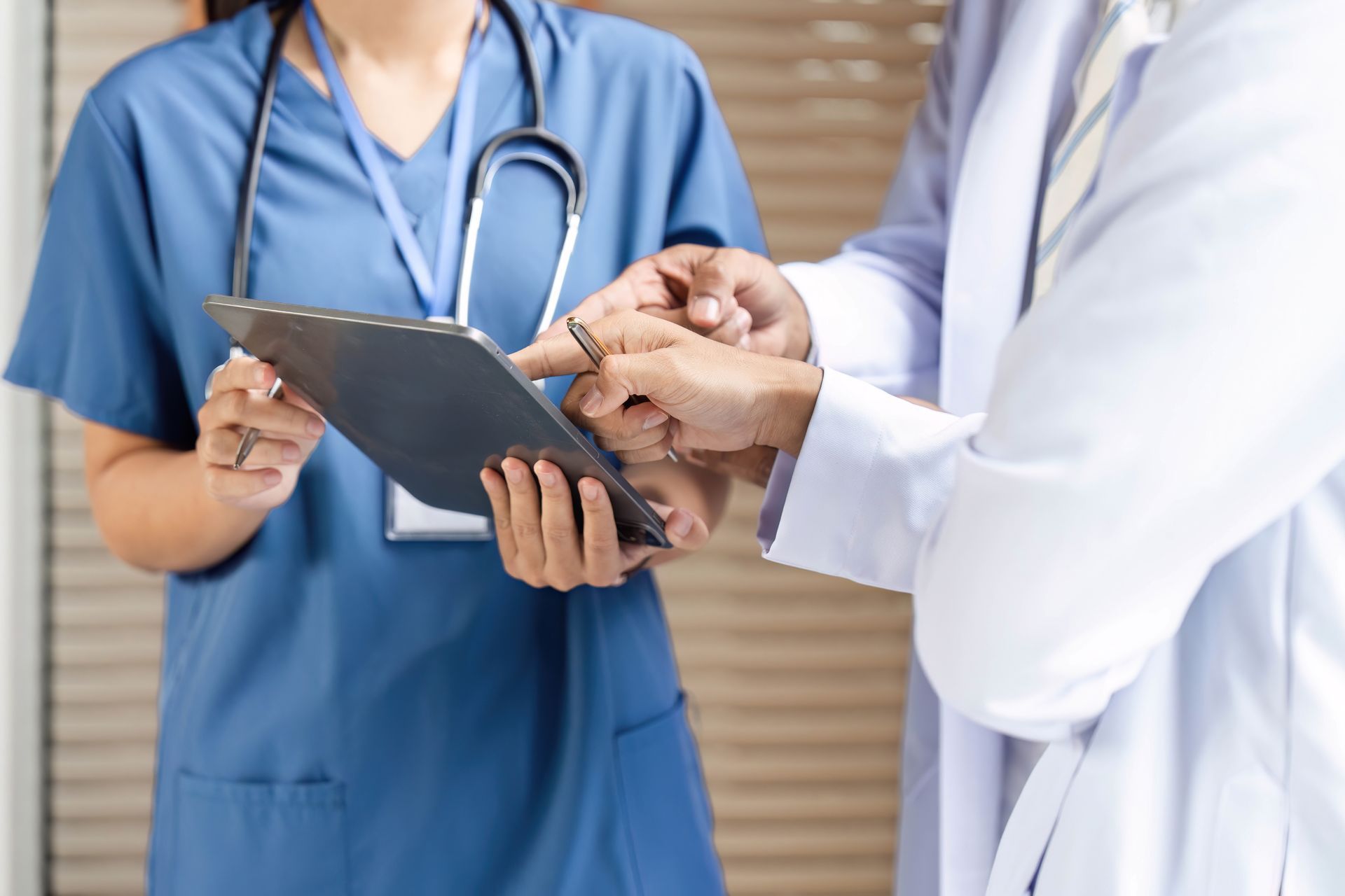 Nurse and doctor reviewing tablet; healthcare setting.