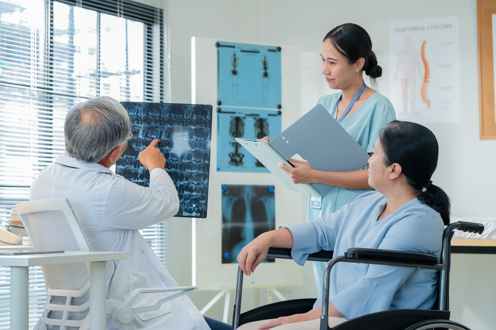 Doctor pointing at X-ray with a nurse and patient in a wheelchair in a medical office. Doctor pointing at X-ray with a nurse and patient in a wheelchair in a medical office.