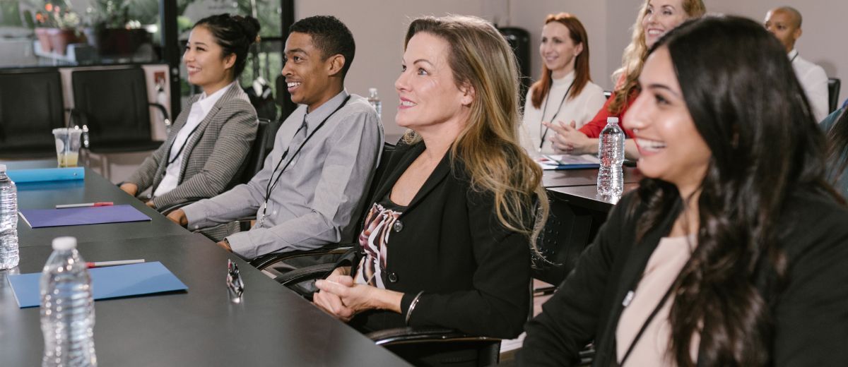People seated at a conference table listening during a presentation