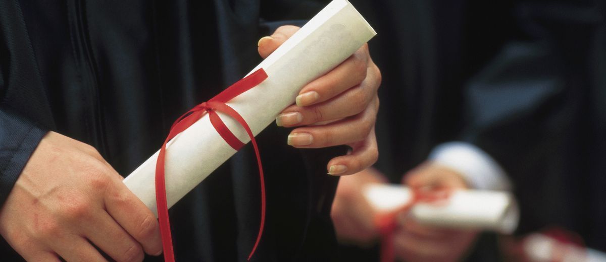 Profissional segurando diploma com fita vermelha: skills-based hiring e contratação por competência