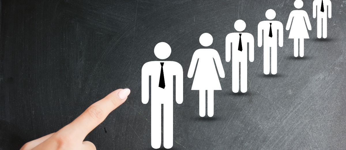 Mão apontando para fila de figuras de pessoas: candidatos que somem no meio do processo seletivo