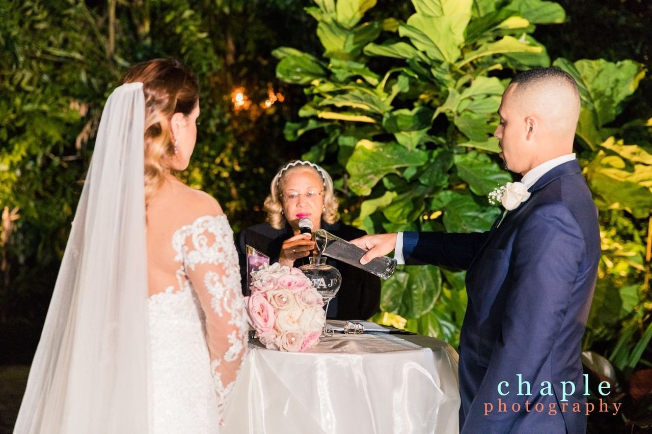 Bride and groom during wedding vows at an outdoor ceremony, with an officiant beside them