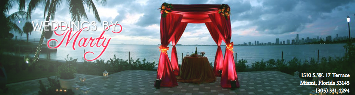 Red draped wedding arch beside a waterfront, with a &ldquo;Merry&rdquo; script on the left and event text on the right.