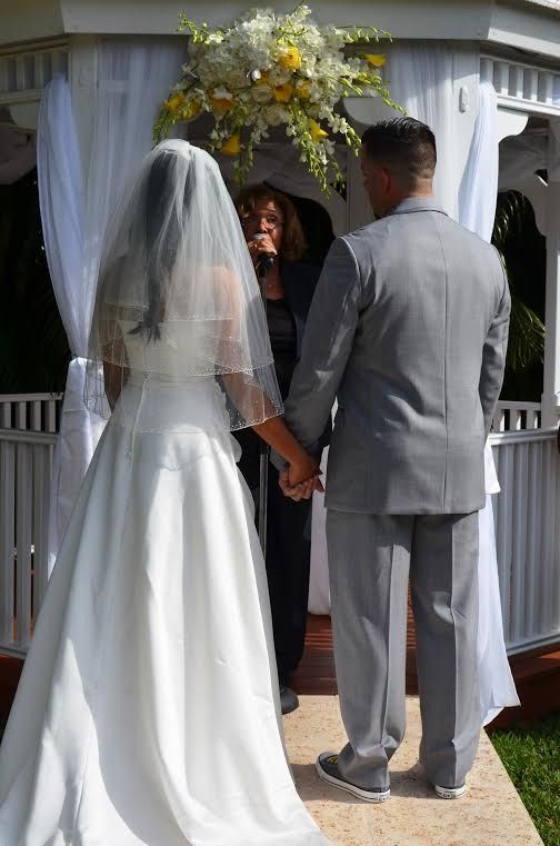 Bride and groom holding hands at an outdoor gazebo wedding ceremony