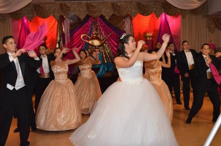 Bride and attendants dancing at a formal wedding reception in a decorated ballroom