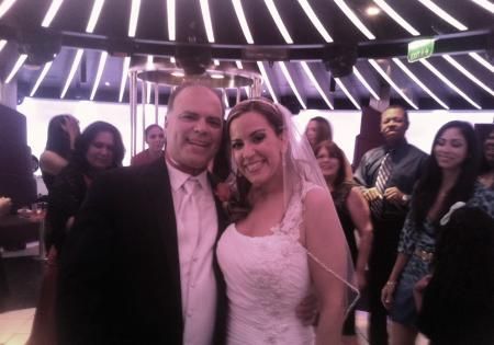 Couple smiling and posing at a party under purple-lit ceiling lights