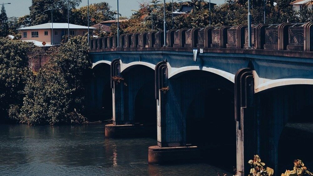 A Bridge over a Body of Water with A House — Innisfail Auto Electrics Pty Ltd in Innisfail, QLD