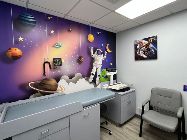A doctor 's office with a painting of an astronaut on the wall.
