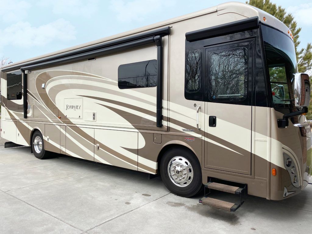 A large rv is parked on the side of the road.