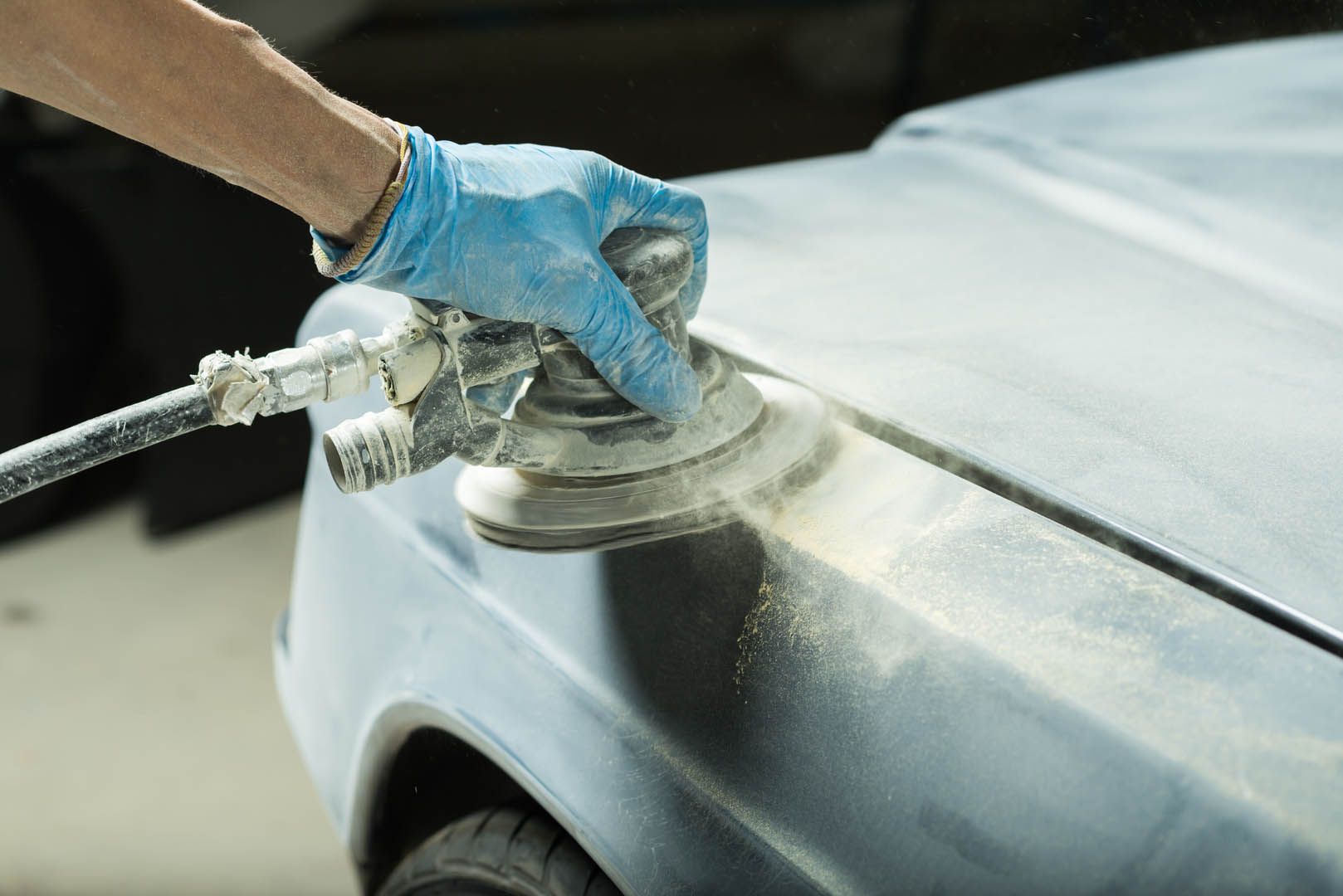 a person is sanding a car with a sander .