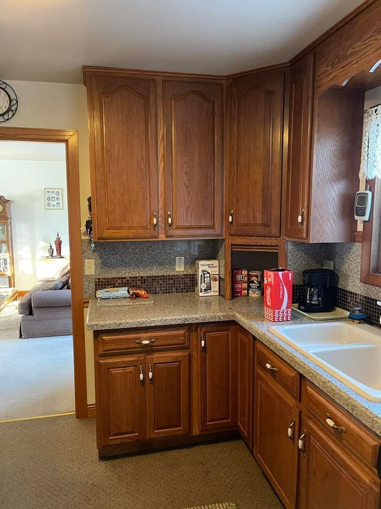 Kitchen corner with wood cabinets, countertop, and a sink.