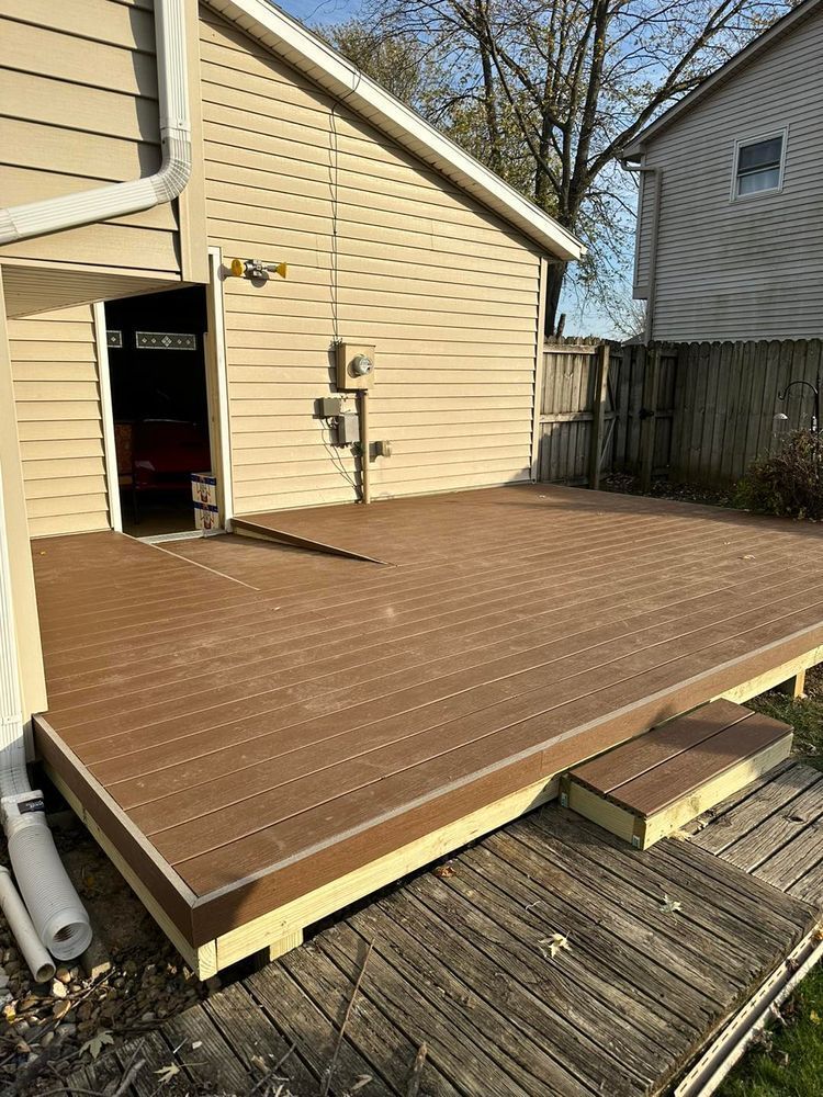 Composite deck with steps. Beige siding, brown deck, and weathered wooden ramp.