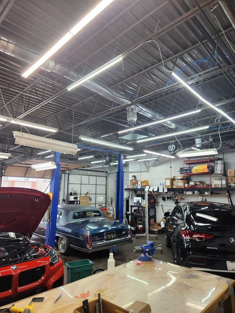 A car is on a lift in a garage with the hood up.