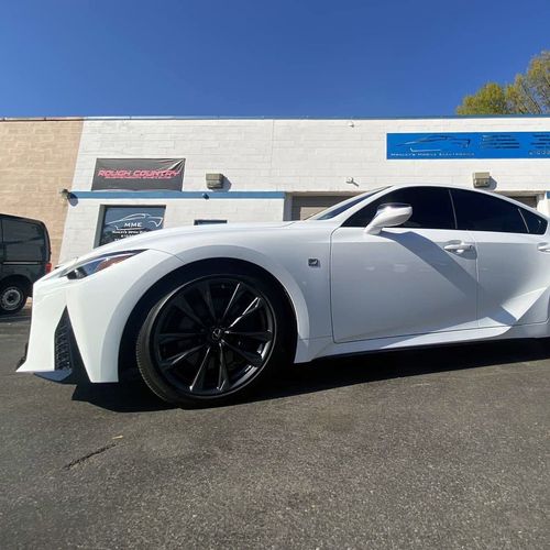 A white sports car is parked in front of a building.