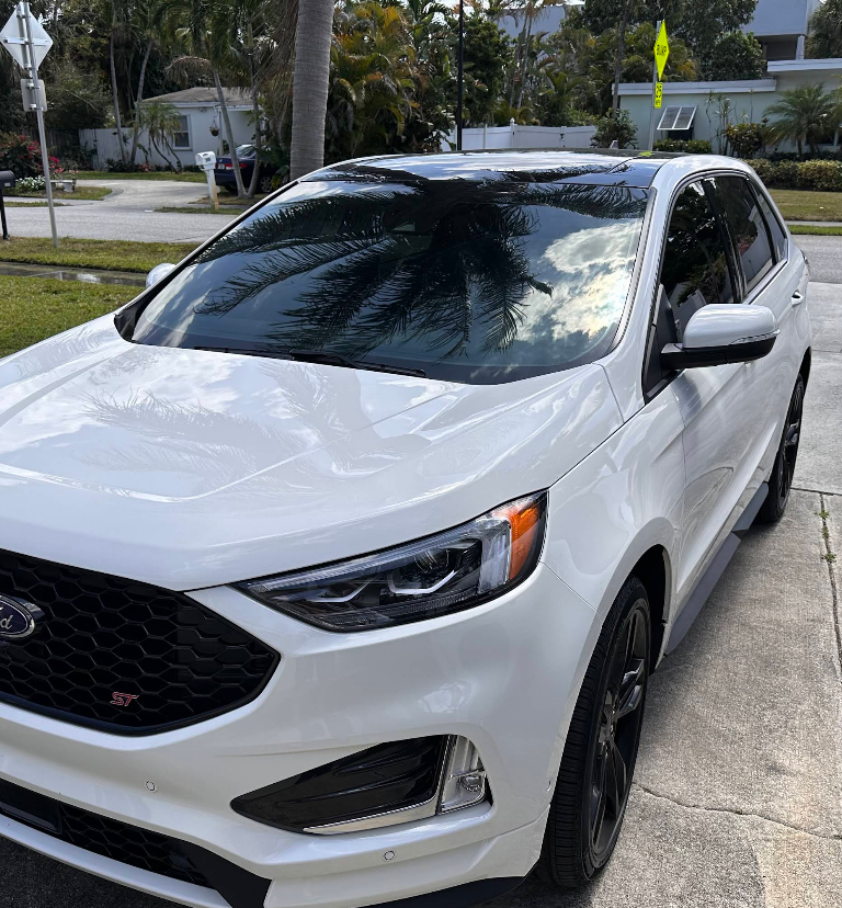 White Ford Edge ST SUV with black accents parked on a paved driveway.