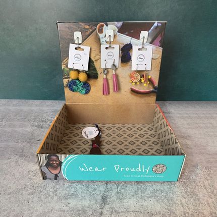brightly colored box with lid turned back to create a jewelry display with hook and earring hanging from it