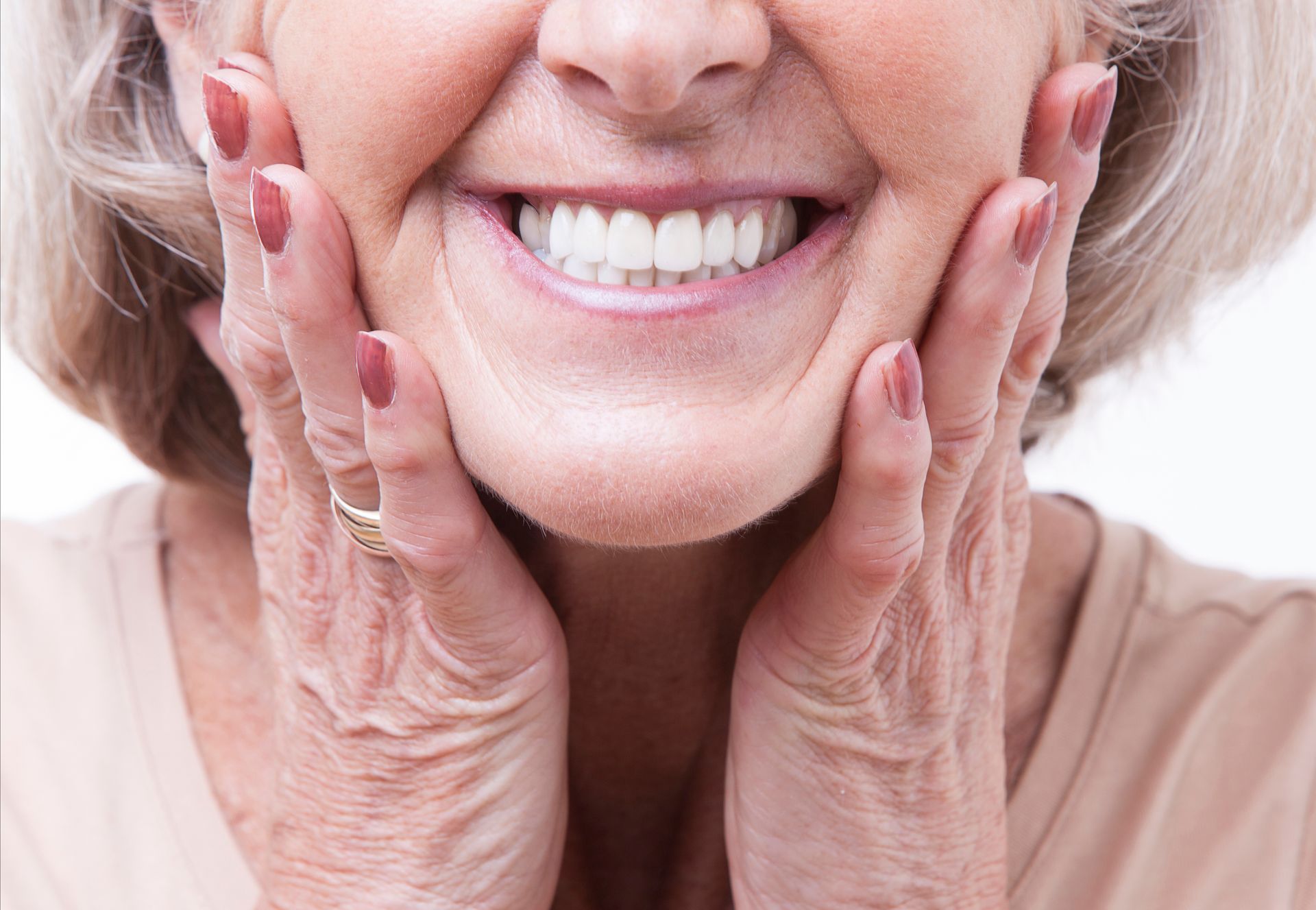 Close-up view of a smiling senior showing her new dentures.