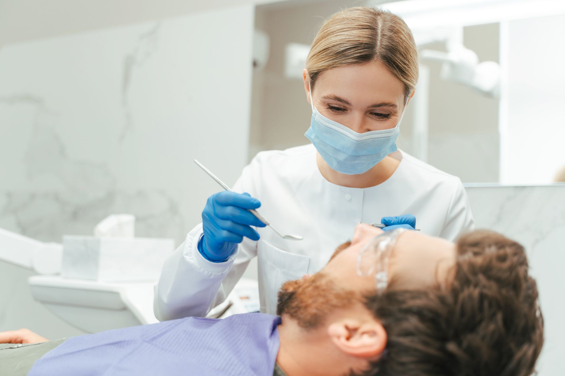 Female dentist examining teeth, specialising in denture repairs and oral health care.