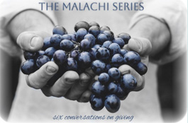 Hands holding a bunch of blue grapes; text 