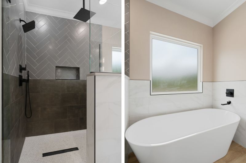 Bathroom with gray tile shower, black fixtures, and white freestanding tub by a window.