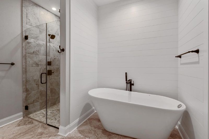 Modern bathroom with a glass shower, freestanding tub, and white walls.