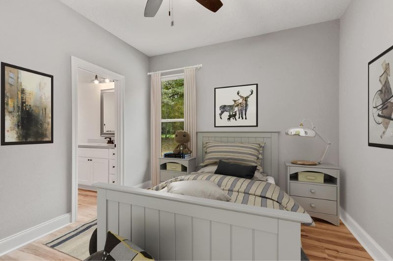 Bedroom with a light gray bed, bedside tables, artwork, and an open doorway to a white bathroom.
